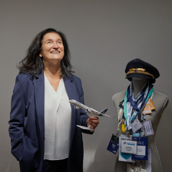 Eine Frau, die mit einem Spielzeugflugzeug in einem Raum steht. 