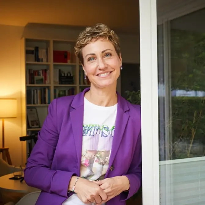 Eine Frau steht an einer geöffneten Tür.