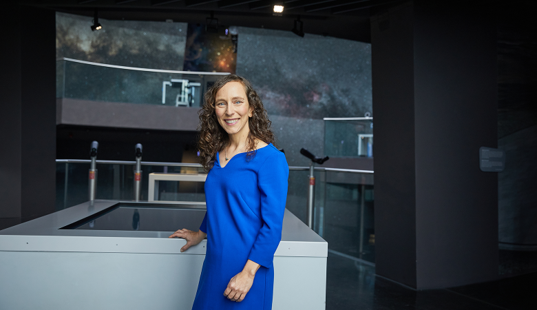 Eine Frau steht in einer Ausstellung zu Sternen.