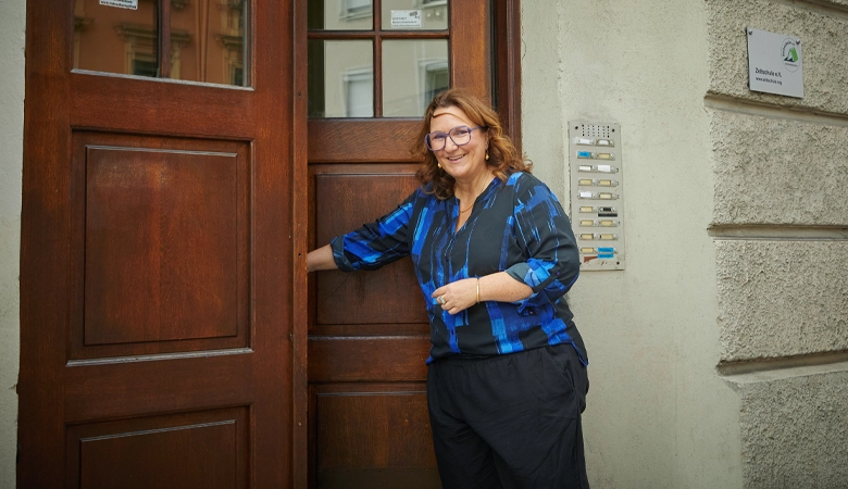 Eine Frau öffnet eine Haustür.