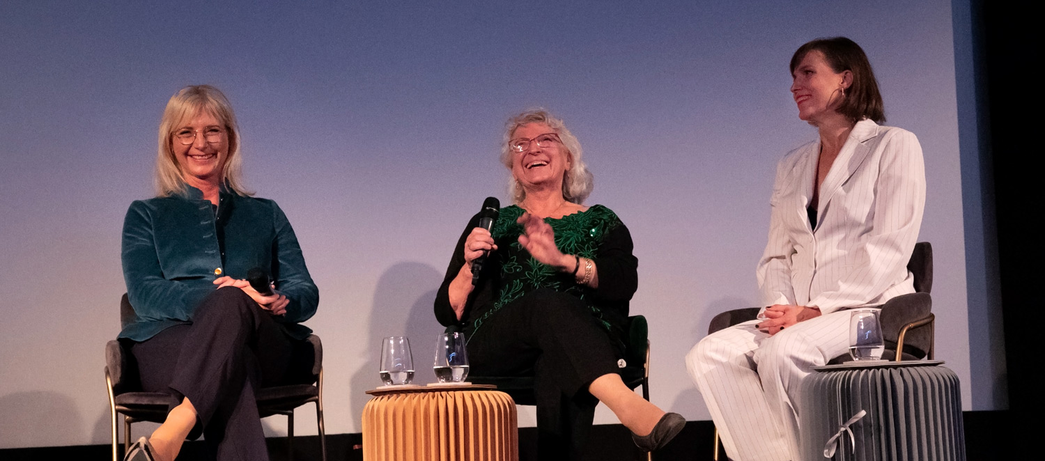 Staatsministerin Ulrike Scharf, Renate Hotz, Yvonne Hotz auf einer Bühne, die drei lachen herzllich.