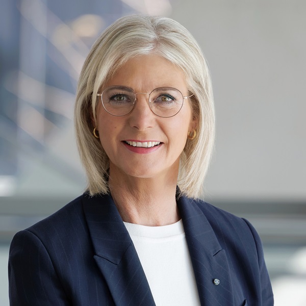 Porträtbild von Staatsministerin Ulrike Scharf mit blonden halblangen Haaren, Brille mit dünnem Metallgestell, dunkelblauem Blazer, weißem Shirt