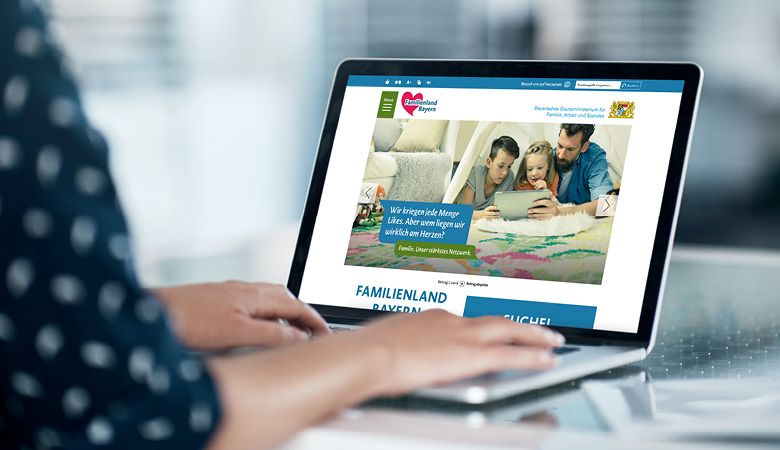 Eine Frau sitzt vor einem Notebook. Sie hat die Website kommweiter.de aufgerufen.