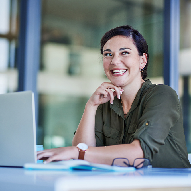 In einem Büro: Eine Frau sitzt am Laptop.