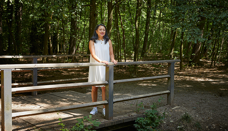 Mai Dang-Goy steht auf einer Brücke im Wald.