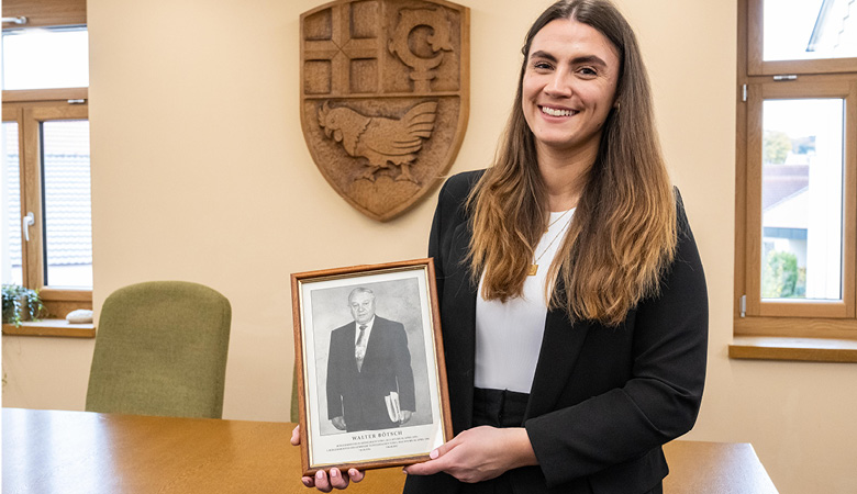 Im Sitzungssaal des Rathauses: Lisa-Marie Schmitt zeigt ein ein gerahmtes Schwarzweißfoto eines Mannes.