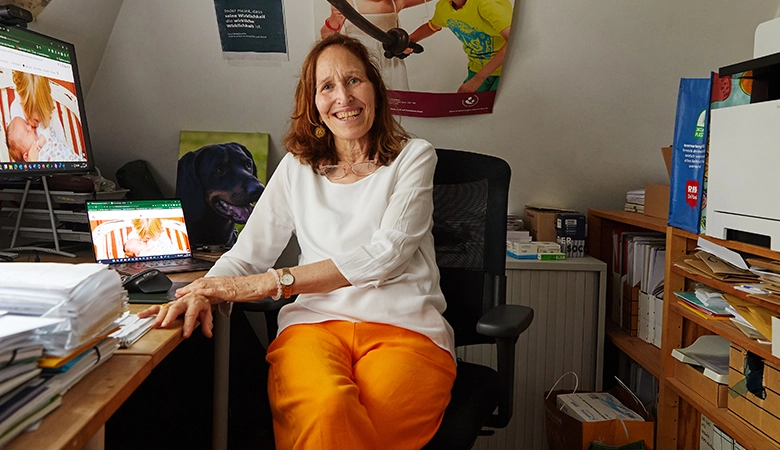 Eine Frau sitzt an einem Schreibtisch mit einem Computer. 