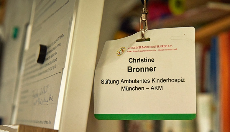 Eine Visitenkarte der Stiftung Ambulantes Kinderhospiz München, die an einer Tafel hängt. 