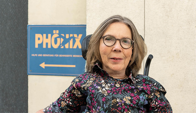 Porträtfoto: Wiebke Richter vor einem Schild des Phönix e. V.