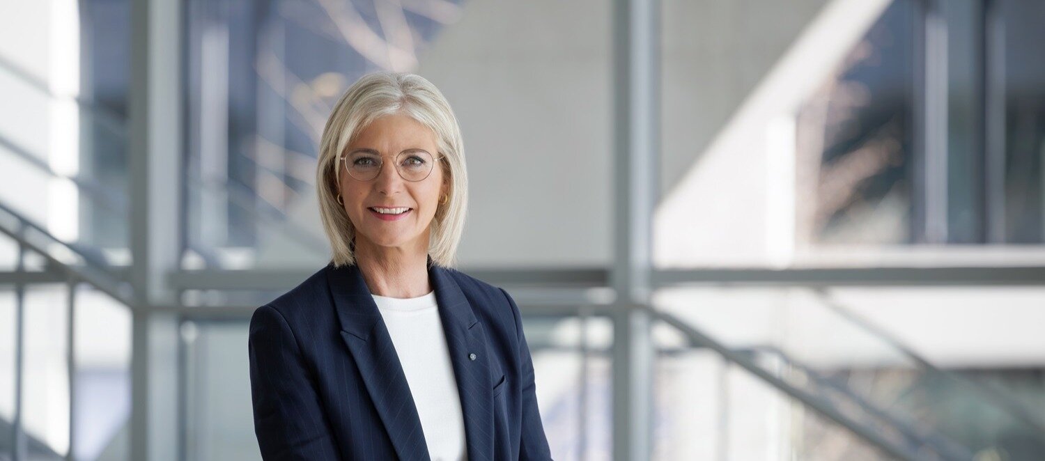 Portraitbild von Staatsministerin Ulrike Scharf - blonde, halblange Haare, metallgerahmte Brille, blauer Blazer, weißes Shirt