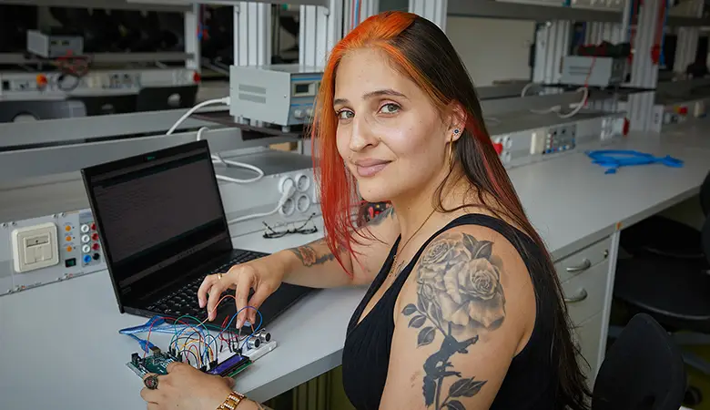 Frau arbeitet an einer elektronischen Schaltung.