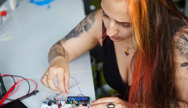 Frau arbeitet an einer elektronischen Schaltung.