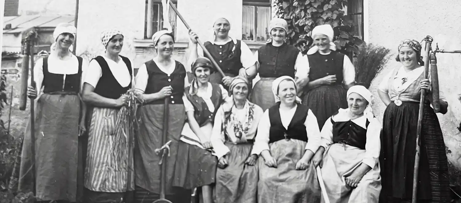 Eine Gruppe von Bäuerinnen um die Jahrhundertwende sitzt zusammen. 