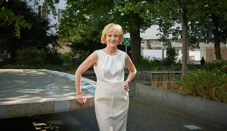 Frau steht an Brunnen