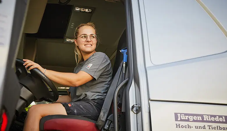 Junge Frau hinter Steuer LKW