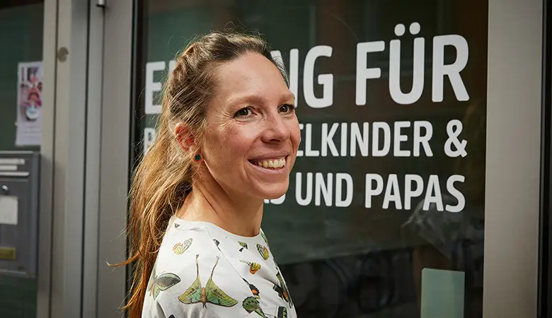 Junge Frau dreht ihr Gesicht zur Kamera und lächelt